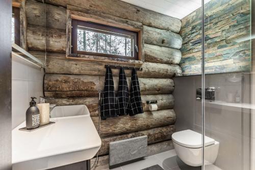a bathroom with wooden walls and a toilet and a window at Villa Riekko by Hillas Villas in Äkäslompolo