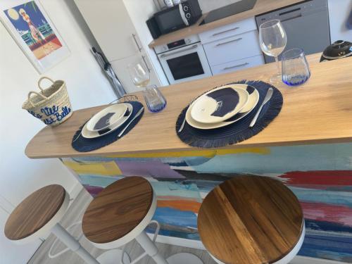 une table en bois avec des assiettes et des verres à vin dessus dans l'établissement 2 pieces Antibes, à Antibes