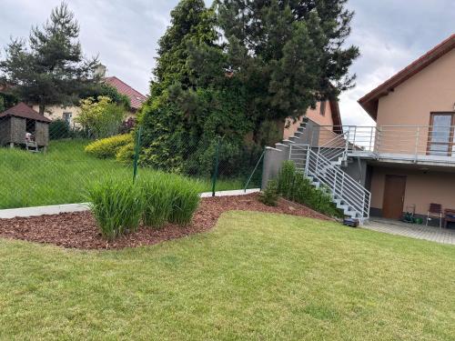 a yard with a house with a staircase and grass at Penzion Čavisov in Čavisov
