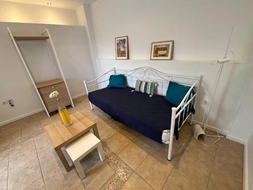 a bedroom with a bed with blue sheets and a table at Portfront Neoclassic Lavrio House in Lávrion