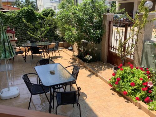 a patio with tables and chairs and flowers at N G Luxury Apartments at Nea Kallikrateia No 2 in Nea Kalikratia