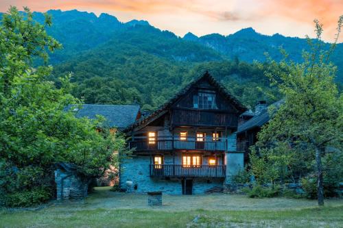 a house in the mountains with the lights on at Chalet Case delle lobbie in Ceppo Morelli
