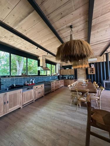 une grande cuisine avec une table et une salle à manger dans l'établissement Chez Babeth Maison atypique en conteneurs pour 10 personnes, à Sizun