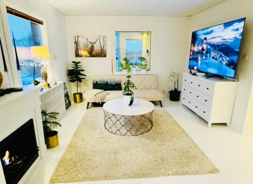 a living room with a tv and a couch and a table at Villa Solborg in Mölnlycke