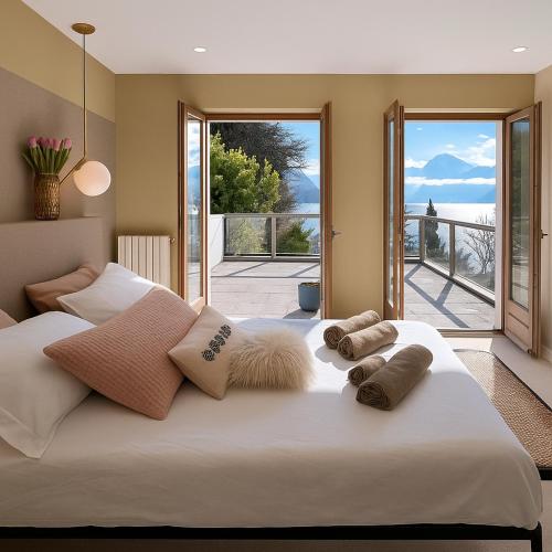 une chambre avec un grand lit blanc avec des oreillers dans l'établissement Villa ACMÉ 200 m du lac d'Annecy avec Jacuzzi, à Rovagny