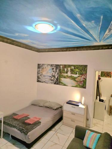 une chambre avec un lit avec un plafond bleu dans l'établissement Charmant appartement ensoleillé à deux pas de Monaco, à Beausoleil