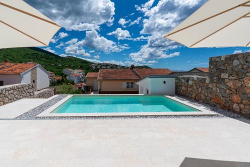 a swimming pool in a villa with a stone wall at Ferienhaus Sana in Klenovica