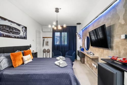 a bedroom with a blue bed and a tv at Fat Cow Apartments in Larnaka