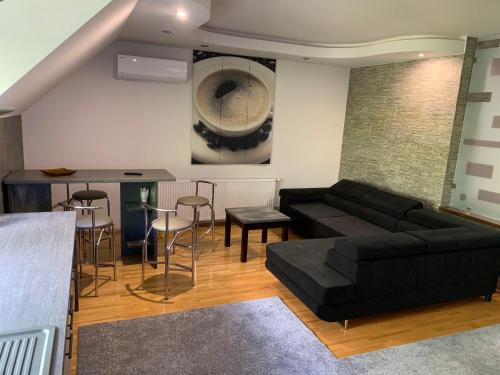 a living room with a black couch and a bar at Green Garden Apartments in Kaunas
