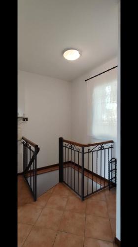 a room with a staircase and a white wall at Casa Sophie in Consiglio di Rumo