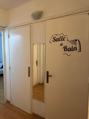 une porte blanche avec un panneau de vente de bain dessus dans l'établissement Le cantini, à Marseille