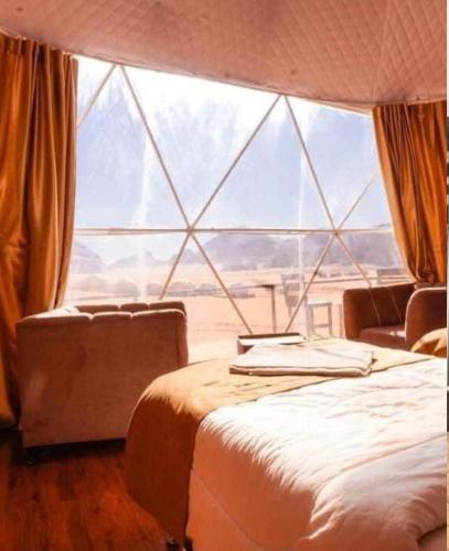 a room with two beds in front of a large window at Rum gate camp Fares in Disah