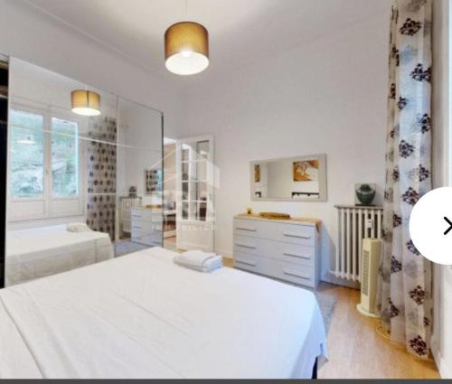 - une chambre blanche avec un lit, un lavabo et une baignoire dans l'établissement Appartement, à Nice