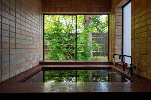 a bathroom with a window and a tub with water at Private Villa 3 minutes from bus stop - in the meantime in Hakone