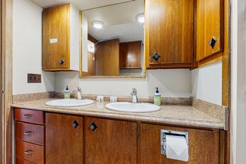 a bathroom with two sinks and a mirror at Riverbank's Pemi Cottage in Lincoln