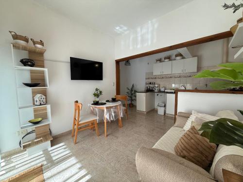 a living room with a couch and a table and a kitchen at VIA VALENTINA "el deseo de volver" departamentos temporales sobre Av Eden centro in La Falda