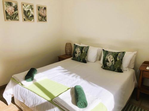 a bedroom with a large white bed with green pillows at Villa Arroyo, Estuary Estate, Port Edward in Port Edward