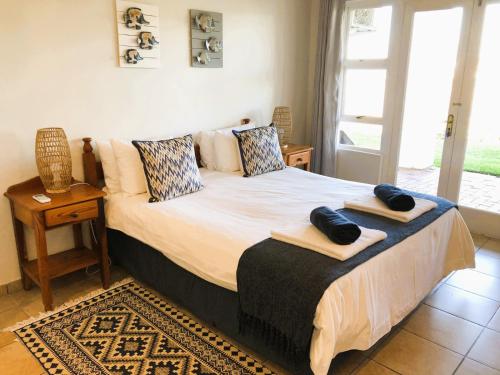 a bedroom with a bed with two towels on it at Villa Arroyo, Estuary Estate, Port Edward in Port Edward