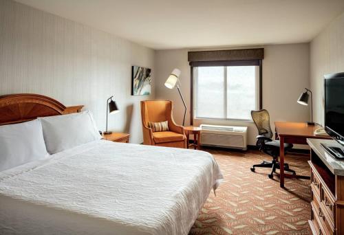 a hotel room with a bed and a desk and a television at Hilton Garden Inn Tri-Cities/Kennewick in Kennewick