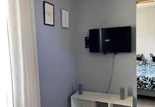 a living room with a flat screen tv on a wall at Le pré tanné in Villers-sur-Mer