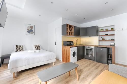 une petite chambre avec un lit et une cuisine dans l'établissement Nazareth Sentier I Charming apartment 1BR 4P, à Paris