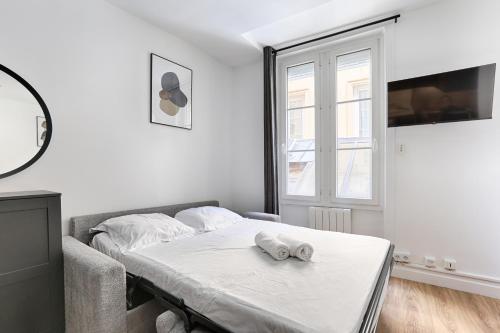 une chambre blanche avec un lit et une fenêtre dans l'établissement Nazareth Sentier I Charming apartment 1BR 4P, à Paris