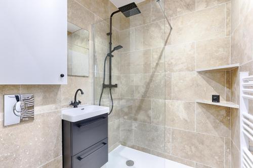 une salle de bain avec douche et lavabo dans l'établissement Nazareth Sentier I Charming apartment 1BR 4P, à Paris