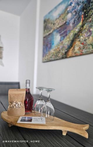 a wooden tray with glasses and wine bottles on a table at Wave Whisper Home in Vathí