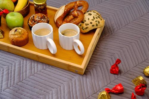 a tray of food with two cups of coffee and pretzels at Fat Cow Apartments in Larnaka