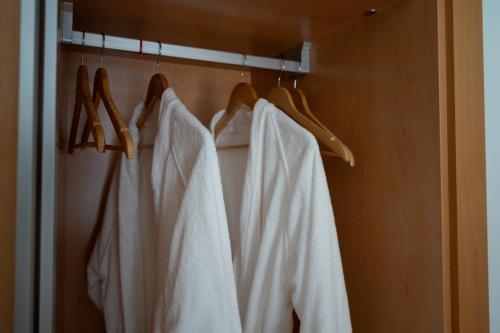 a row of white robes hanging on a rack at HolidaysPT 1 - Marina Village 2 bedroom apartment in Olhão