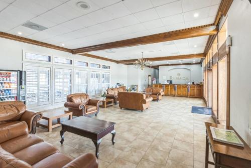 Una sala de estar con sofás y sillas y una mesa. en Ramada by Wyndham Houma, en Houma