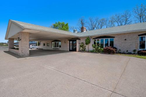 a house with a driveway in front of it at Days Inn by Wyndham Whitmore Lake Near Ann Arbor And Brighton in Whitmore Lake