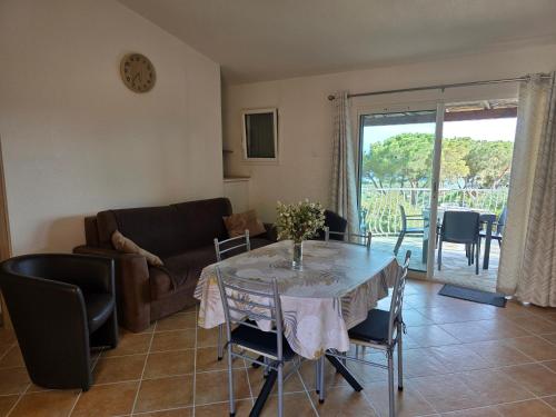 un salon avec une table et un canapé dans l'établissement Mini villa Paesolu, à Porto-Vecchio
