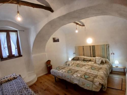 a bedroom with a large bed with an arched ceiling at B&B 8A CASTELBIANCO in Castelbianco