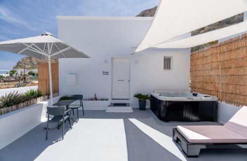a patio with a tub and a table and chairs at Kamara Sea View Studio in Kamari
