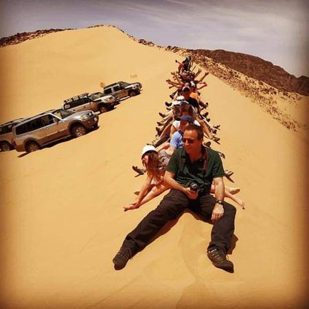 a group of people sitting in a desert at Rum gate camp Fares in Disah