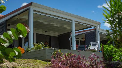 a screened in porch on a house with plants at Galanterie in Grand-Bourg