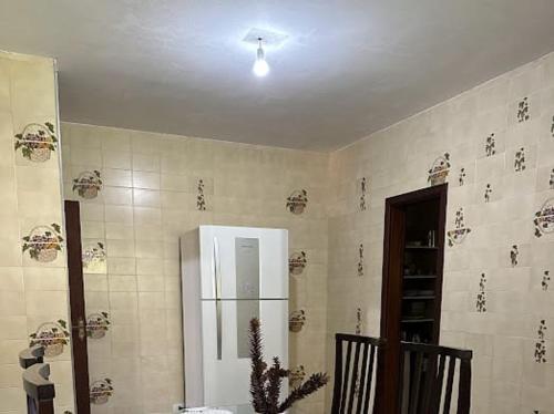 a kitchen with a white refrigerator in a room at Pequeno Paraiso in Campos do Jordão