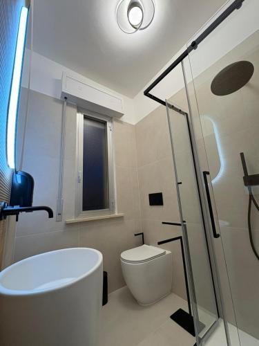 a bathroom with a toilet and a glass shower at La Perla Saba 2 in Montemarciano