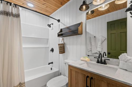 a bathroom with a sink and a tub and a toilet at The Hideaway at Grassy Branch by Venture Smoky Mountains in Sevierville