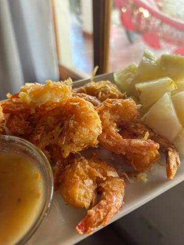 a plate of food with chicken and vegetables and a sauce at Hotel Tranquilo in Las Peñitas