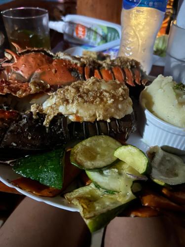 a plate of food with a lobster and vegetables on a table at Hotel Tranquilo in Las Peñitas