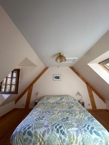 une chambre avec un lit dans un grenier dans l'établissement Gite en bord de Seine, à Villequier