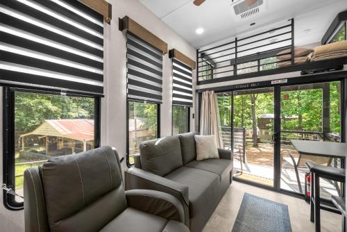 a living room with a couch and chairs and windows at Glamping at KY Lake 1 min from Carper Cove in Springville
