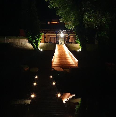 a bridge over a pond at night with lights at Beach House Orfű in Orfű
