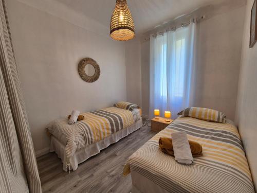 une chambre avec deux lits et un miroir dans l'établissement Carolina, T3 centre historique de Bandol, à Bandol