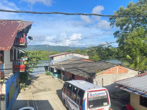 a bus driving down a street next to buildings at La posada in Nuquí