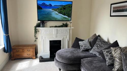 a living room with a couch and a tv over a fireplace at Victorian Town House in the Heart of Dover in Dover