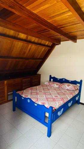 a blue bed in a room with a wooden ceiling at CHALET SANTORINI in Calima