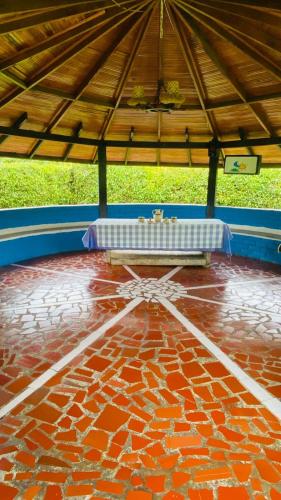 a pavilion with a red brick floor with a table at CHALET SANTORINI in Calima